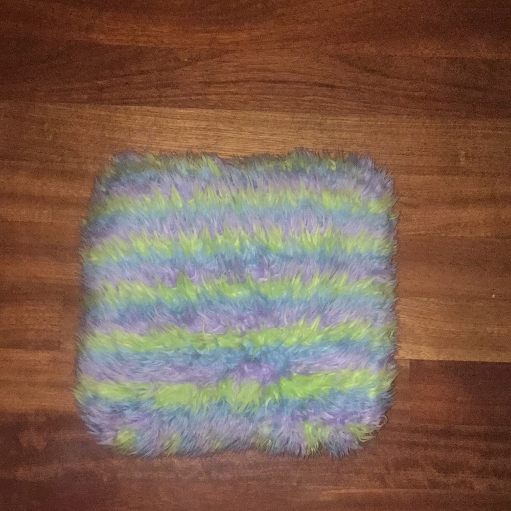 A purple and turquoise and green fluffy pillow